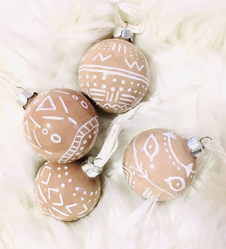 three brown and white ornaments sitting on top of a white fur covered floor next to each other