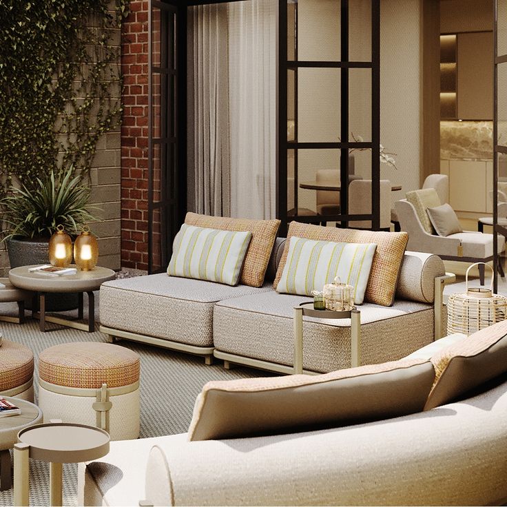 a living room filled with lots of furniture next to a brick wall and patio area