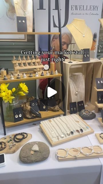 a table topped with lots of jewelry on top of a white table covered in wooden boxes