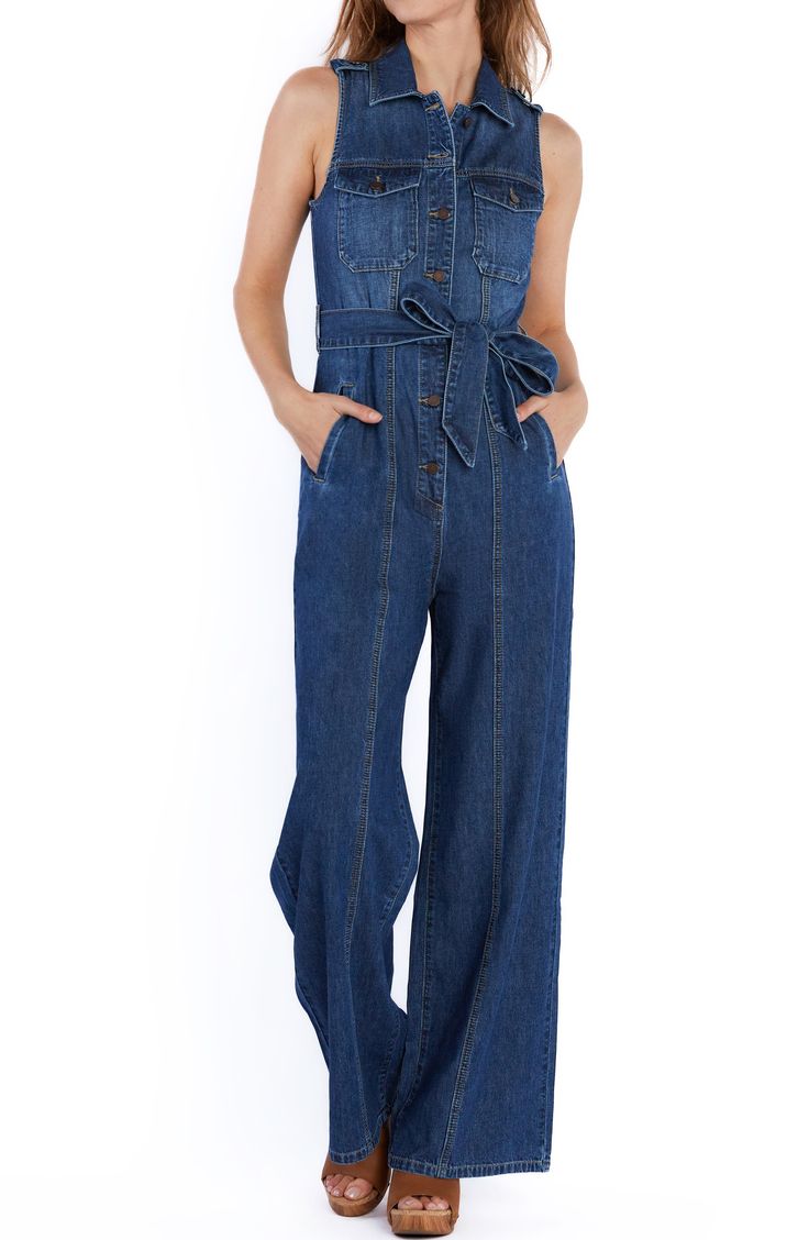 Brassy buttons and sweeping wide legs add character to a fitted denim jumpsuit equipped with handy side pockets. 60" length Front button closure Point collar Sleeveless Chest button-flap patch pockets; side-seam pockets Removable tie belt Unlined 100% cotton Machine wash, tumble dry Imported Dark Wash Utility Denim Jumpsuit With Bib Front, Utility Style Dark Wash Denim Jumpsuit With Bib Front, Denim Blue Overall Jumpsuit With Button Closure, Dark Wash Wide Leg Jumpsuits And Rompers With Pockets, Utility Style Denim Blue Bib Front Jumpsuit, Utility Denim Blue Jumpsuit With Bib Front, Utility Denim Jumpsuit With Buttons In Medium Wash, Utility Style Denim Jumpsuit With Buttons, Utility Denim Jumpsuits And Rompers With Button Closure