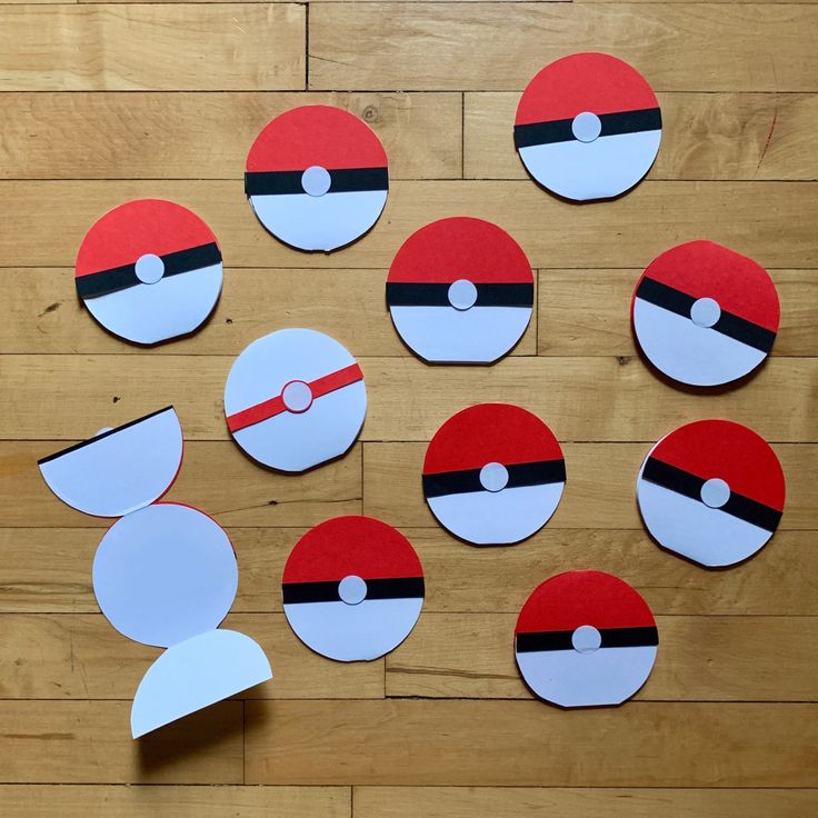 paper cut out of different types of pokemons on a wooden floor with scissors and tape