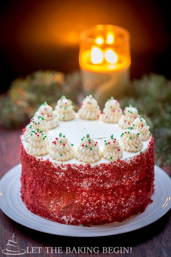 a red velvet cake with white frosting and sprinkles on a plate