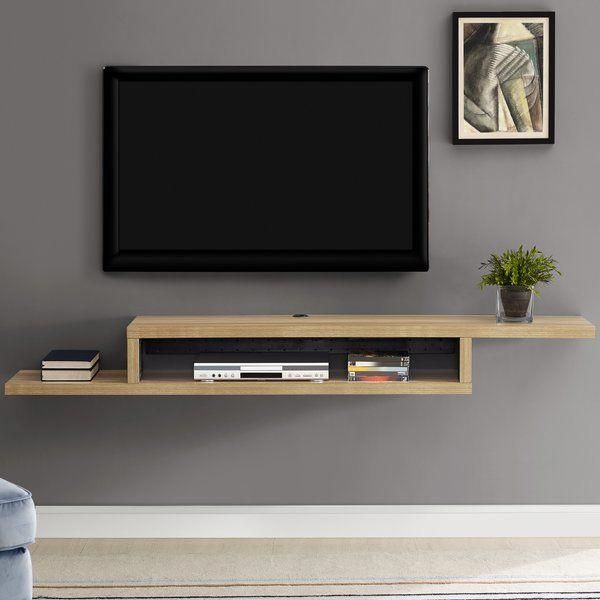 a living room with grey walls and a large flat screen tv mounted on the wall