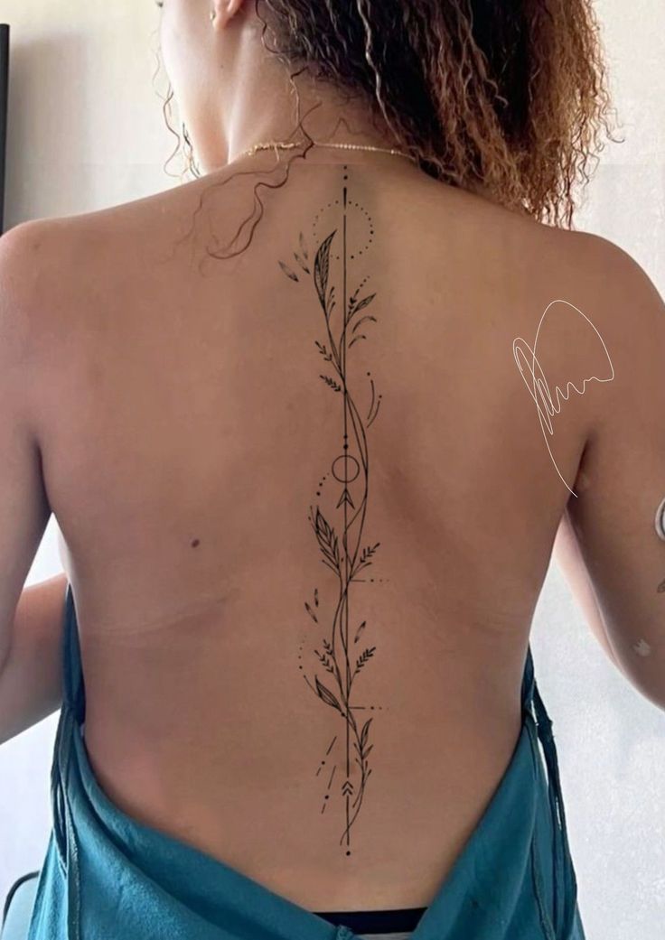 the back of a woman's body with tattoos on her upper and lower back