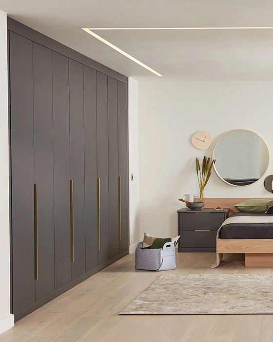 a bed sitting in a bedroom next to a wooden dresser and mirror on top of a hard wood floor