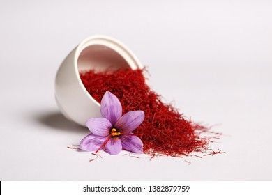 a white cup filled with red stuff and a purple flower