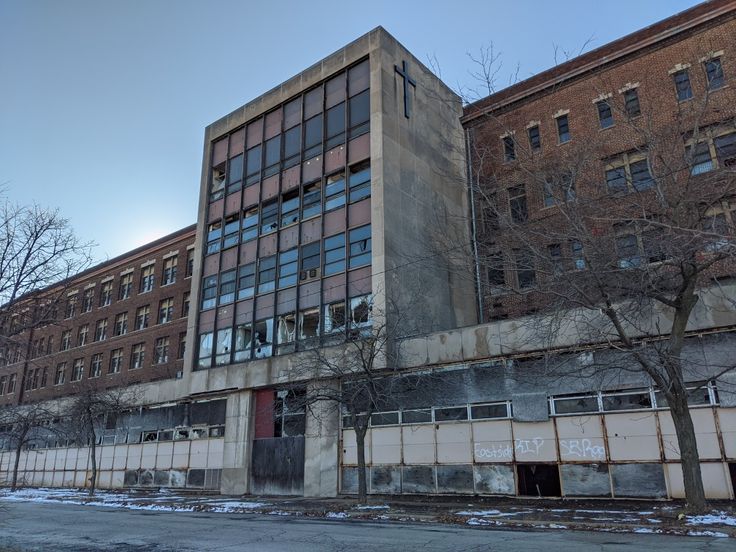 an old building with lots of windows on the side of it and snow covered ground