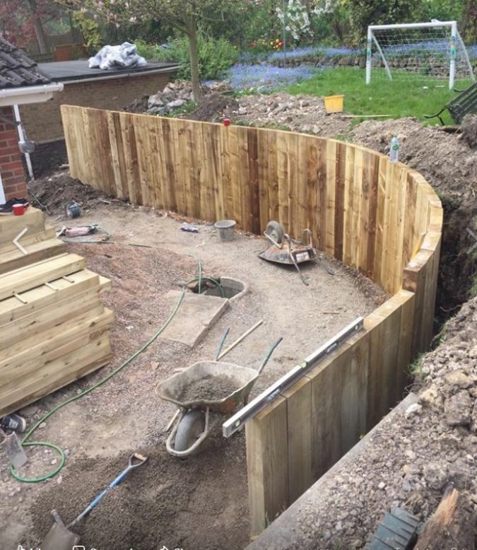 an unfinished backyard with wooden fence and construction materials