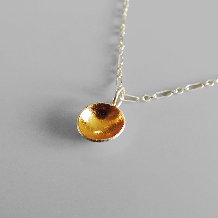 A beautiful and elegant necklace that is small enough to wear everyday but with enough shine to be noticed. Made of sterling silver and finished with 24k gold keum boo on the inside of the dome and hangs from and 18 inch sterling silver chain. Measure: pendant: over a 1/4″ wide or 10mm and over 1/2″ long or 15mm. Hangs from an 18 inch chain. Arrives to you in a gift box with foam padding and tissue paper. This item is a special made to order piece. Please allow me at least one week to complete y Minimalist Domed Jewelry As A Gift, Minimalist Domed Jewelry Gift, Domed Sterling Silver Jewelry For Gifts, Sterling Silver Domed Jewelry Gift, Domed Sterling Silver Jewelry Gift, Gold Domed Jewelry Gift, Yellow Sterling Silver Round Pendant Necklace, Yellow Sterling Silver Necklace With Round Pendant, Minimalist Domed Gold Jewelry