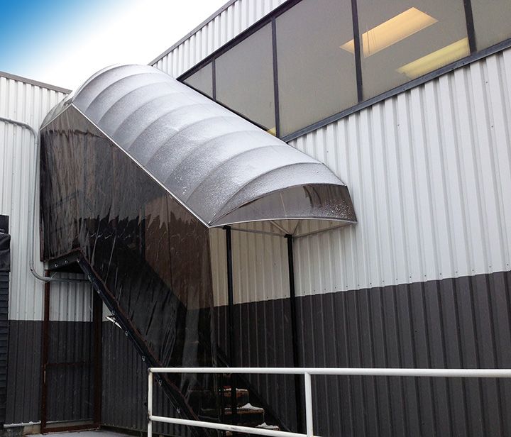 a boat sitting on top of a metal ramp next to a tall building with windows