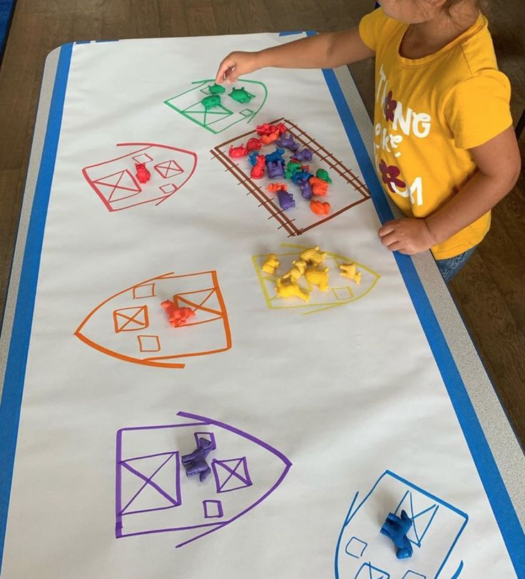 a young child is playing with construction paper and magnets on the mat that he made