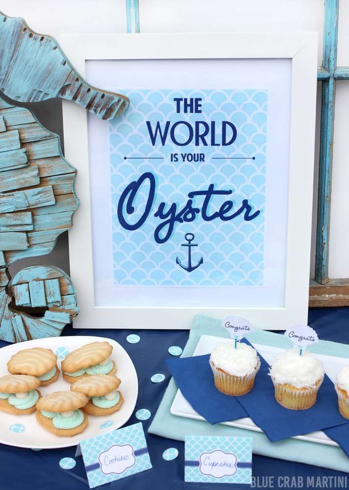 a table topped with cupcakes and cookies next to a framed sign that says the world is your oyster