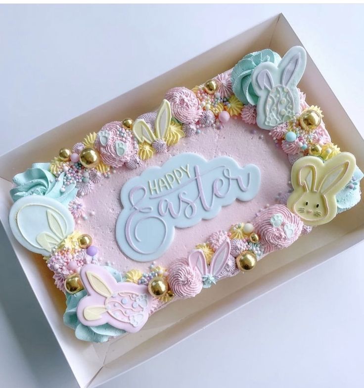 a birthday cake in a box decorated with pastel colors and bunny ears on it