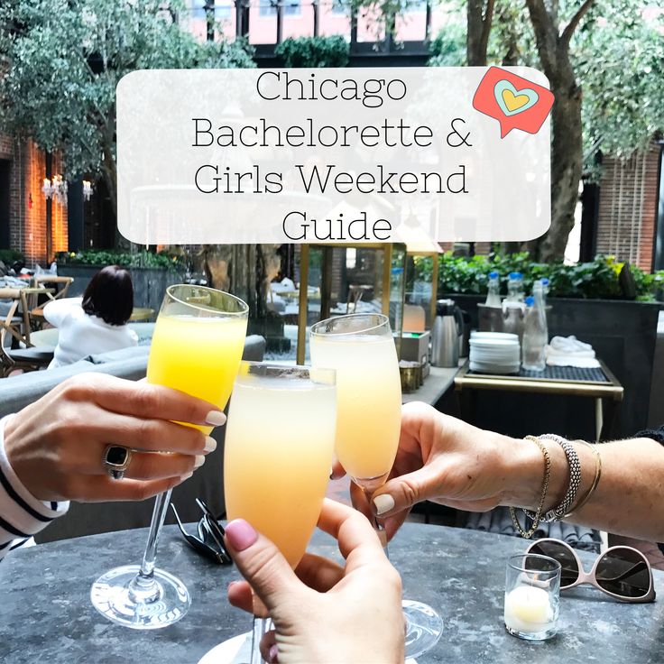 two people toasting with drinks in front of them at an outdoor dining room table