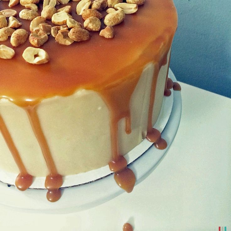 there is a cake with nuts on top and caramel icing drizzle