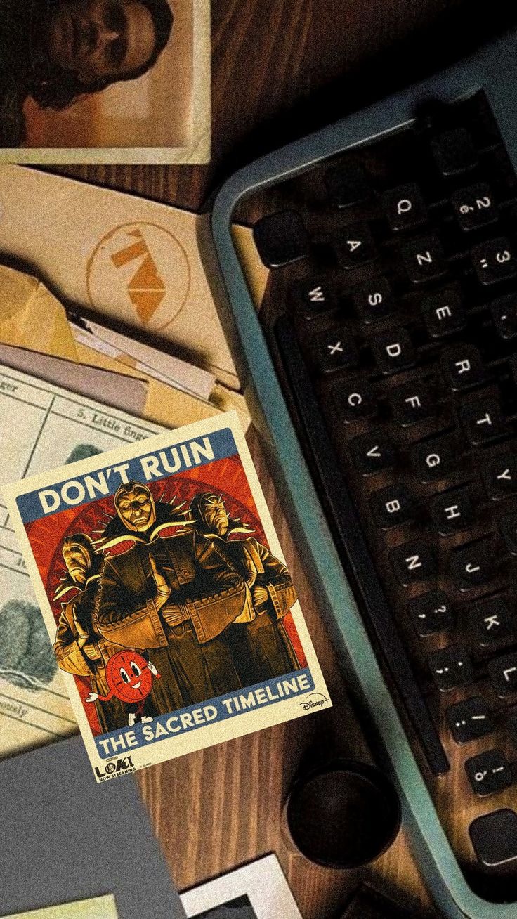 a computer keyboard sitting on top of a wooden desk next to papers and other items