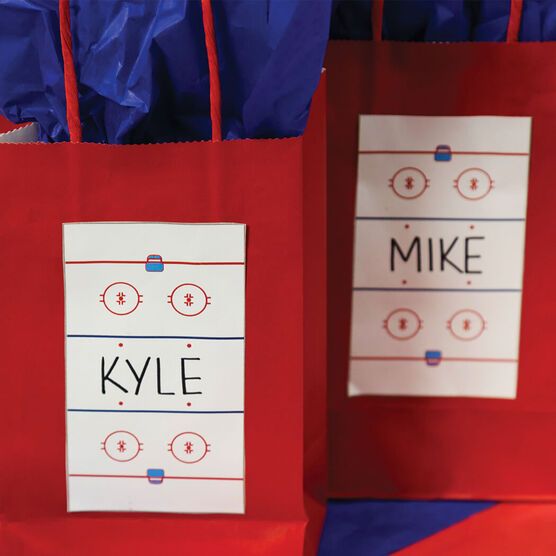 two red bags with name tags on them sitting side by side in front of each other