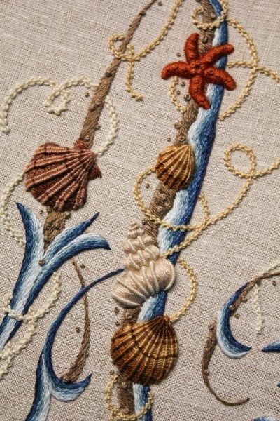 an embroidered design with seashells and starfish on the side of a piece of cloth