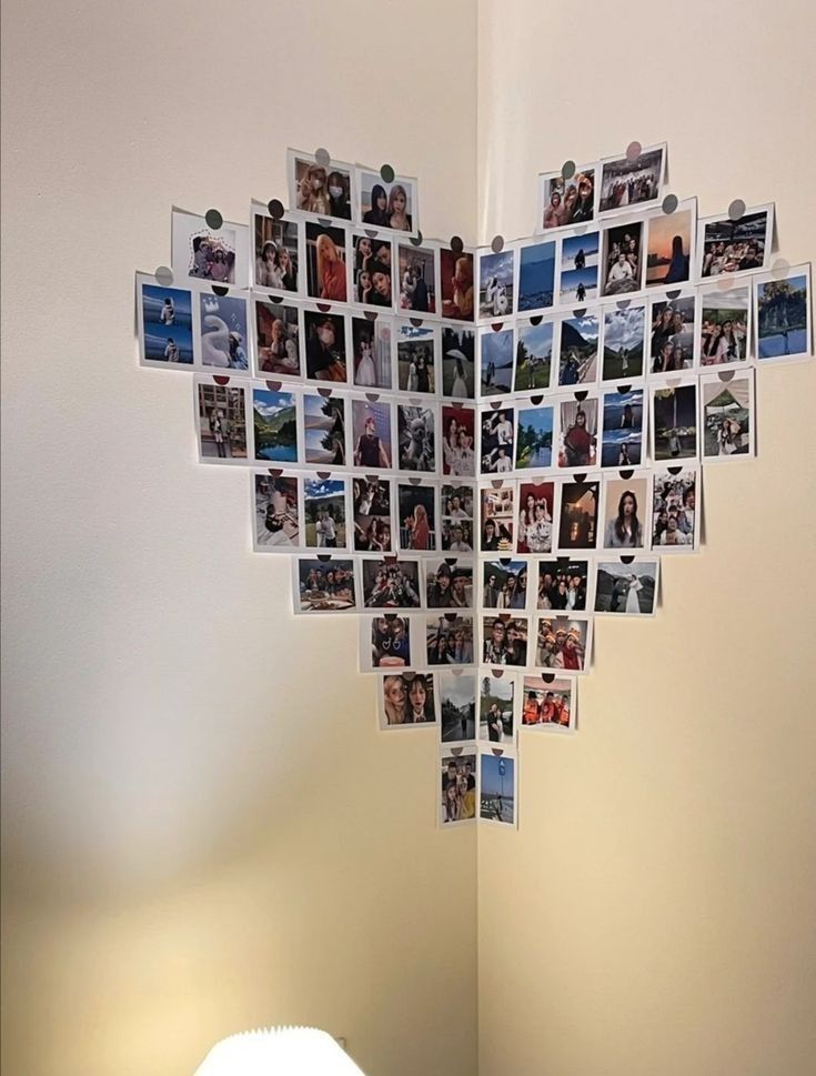 a heart shaped photo collage hanging on the wall next to a bed and lamp