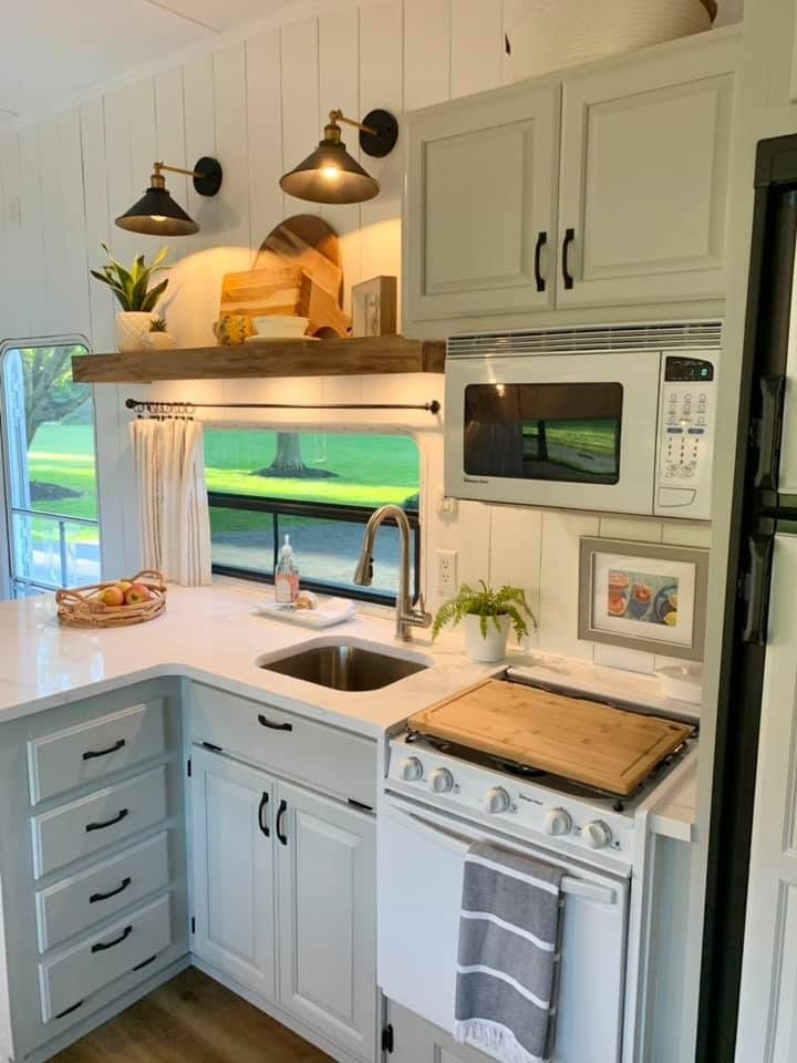 a kitchen with an oven, sink and stove top in the middle of it's counter space