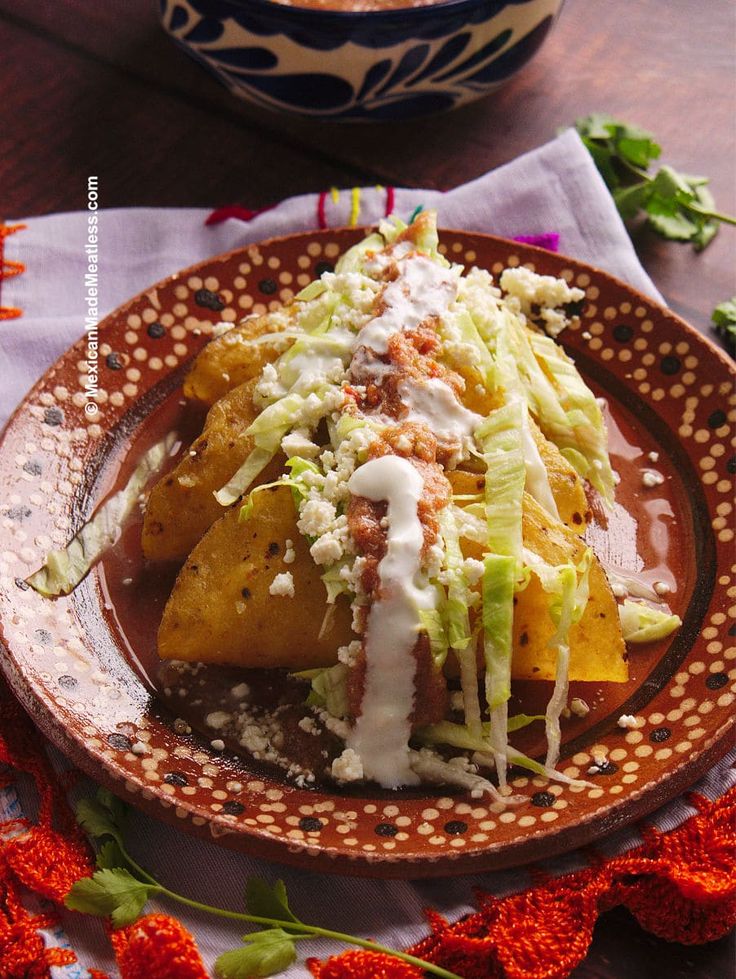 some tacos are sitting on a brown plate