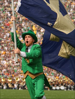 a man in green is holding a flag