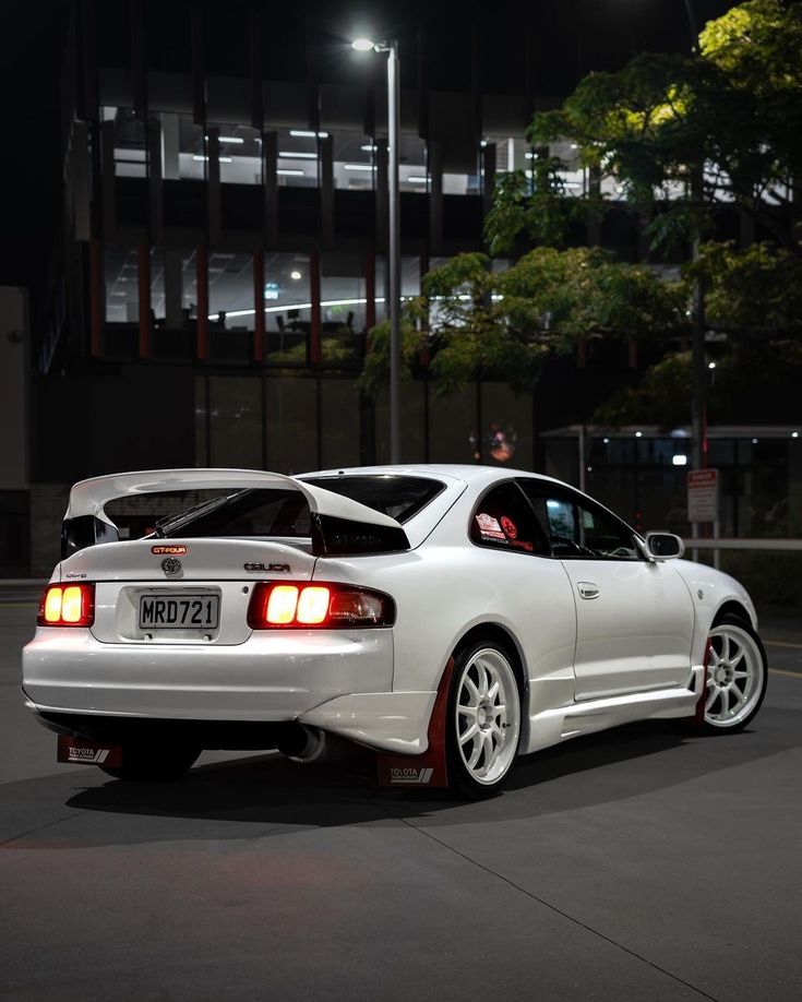 a white sports car parked on the street at night