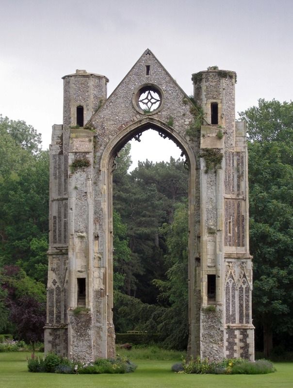 an old stone building with a clock on it's face and windows in the middle