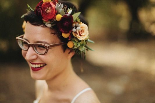 a woman wearing glasses and a flower crown