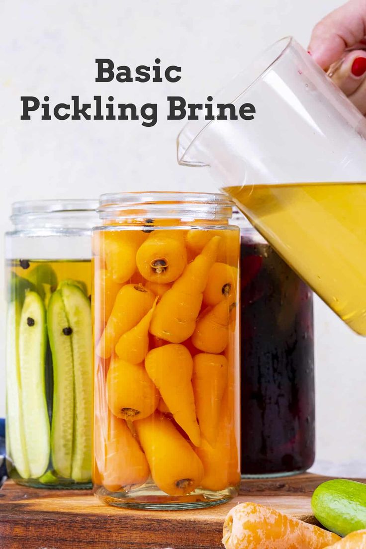 pickling brine is being poured into jars filled with pickles and cucumbers