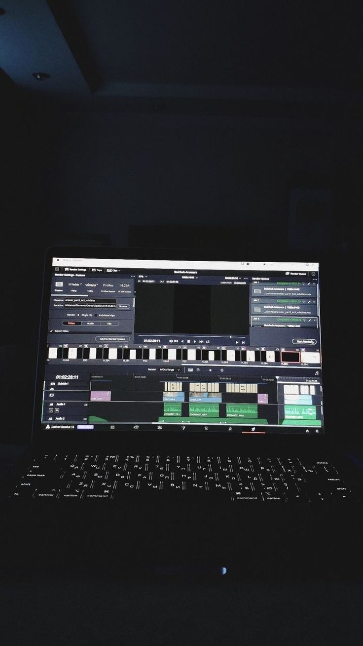 an open laptop computer sitting on top of a dark table in the dark with lots of light