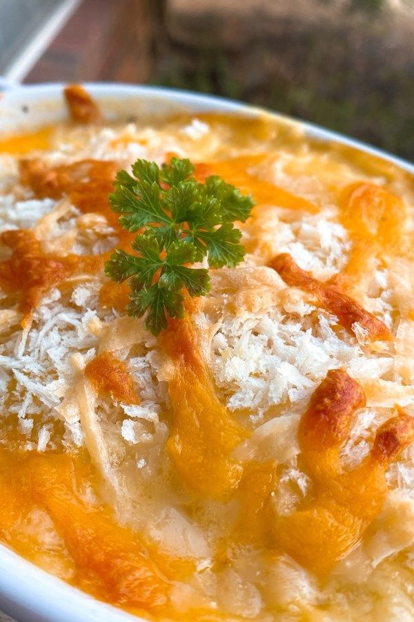 a white bowl filled with food and garnished with parmesan cheese on top