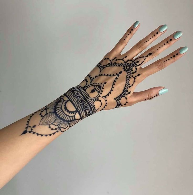 a woman's hand with henna tattoos on it