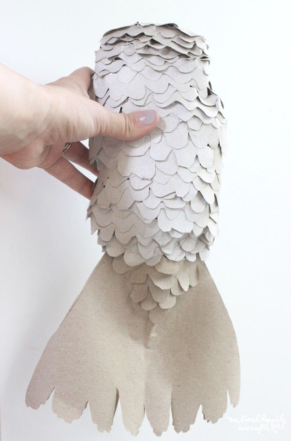 a person is holding up a paper owl