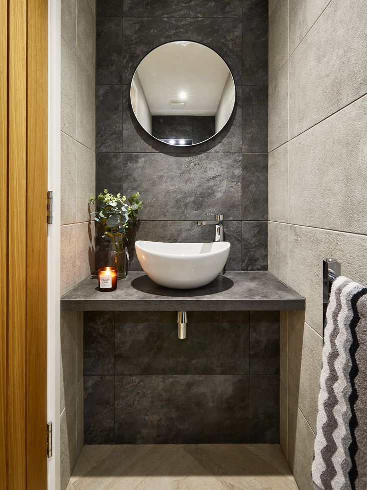 a bathroom with a sink, mirror and towel rack in it's corner area