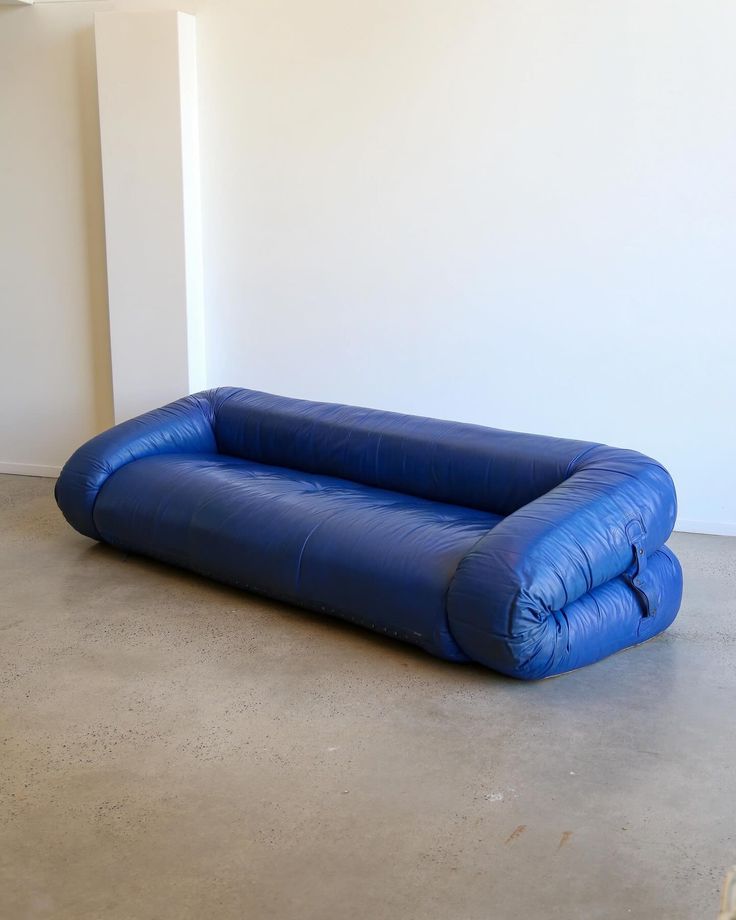 an inflatable couch is sitting on the concrete floor next to a white wall