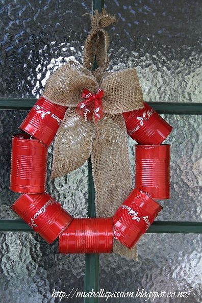 a wreath made out of cans is hanging on the front door