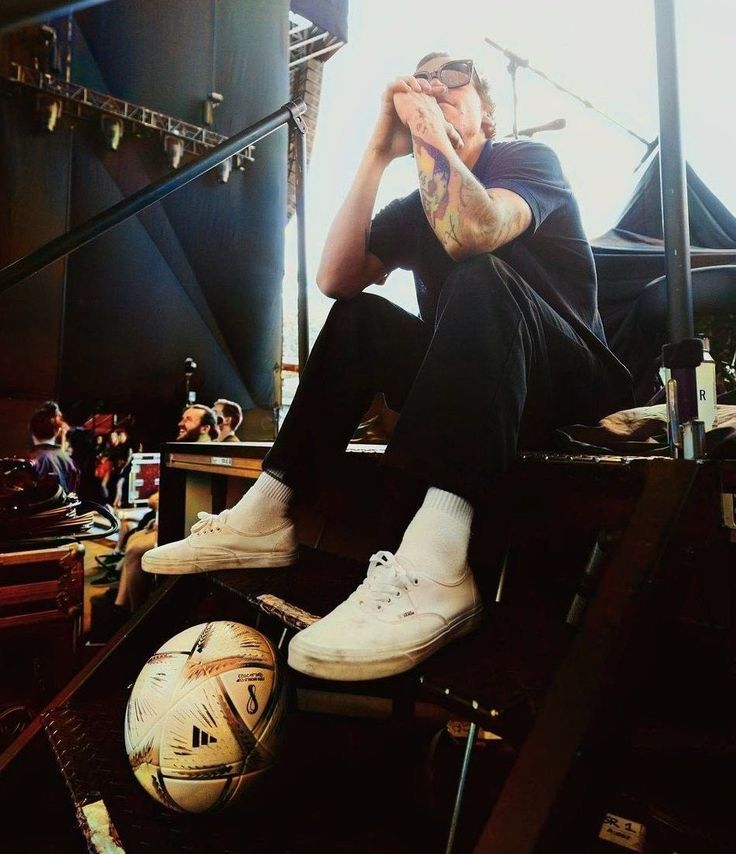 a man sitting next to a soccer ball