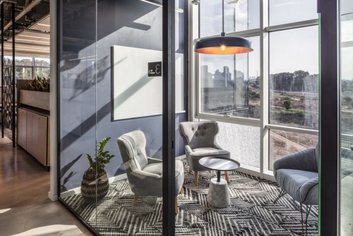 an office with large windows and chairs in front of the glass wall that overlooks cityscape