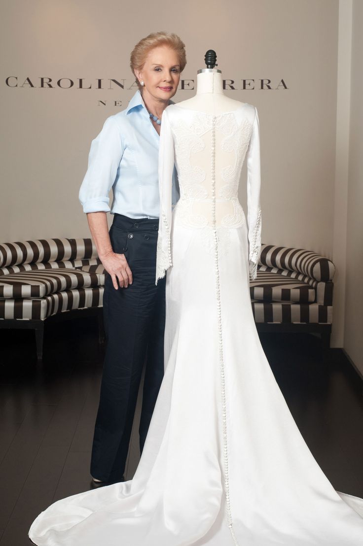 a man and woman standing next to a white dress on a mannequin stand