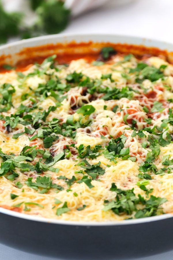 a casserole dish filled with cheese and vegetables