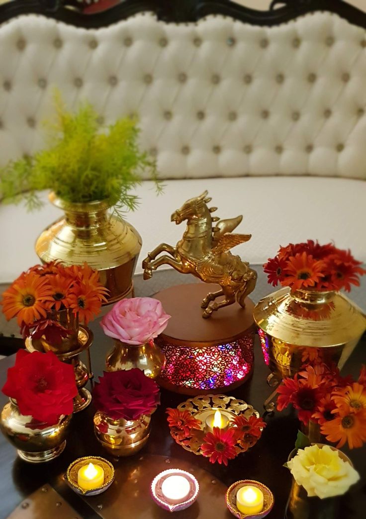 a table topped with vases filled with flowers and candles