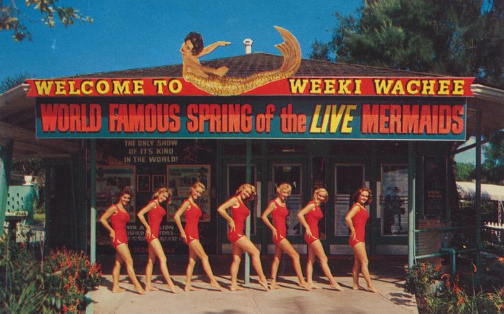 a group of women in red swimsuits walking past a sign for the world famous strip