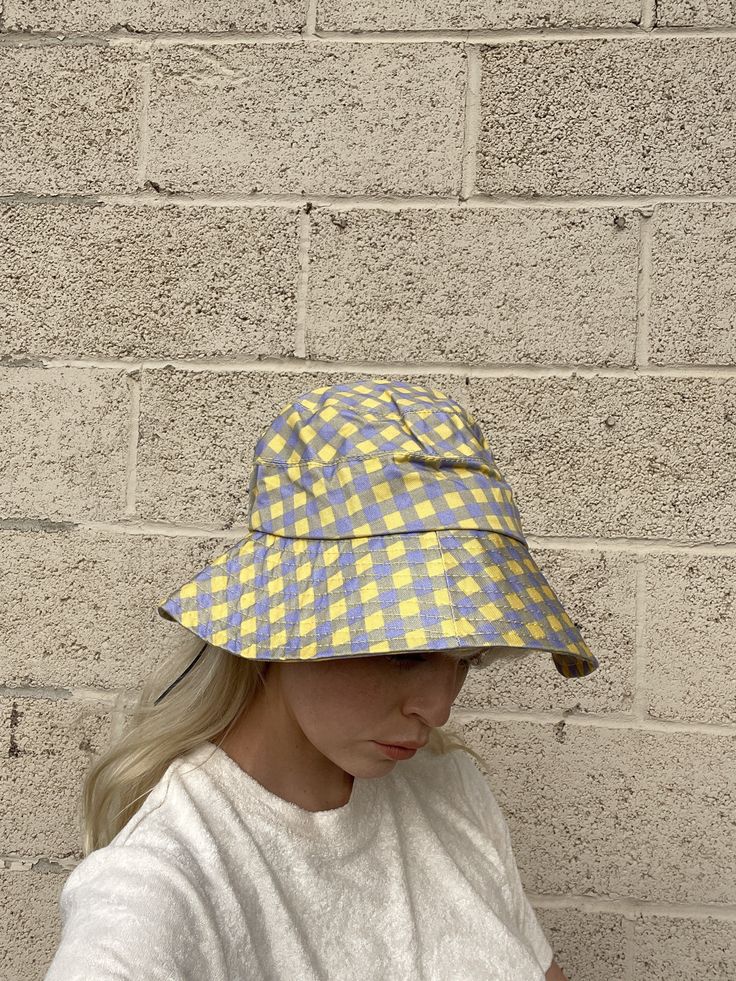 Yellow + Lavender Plaid Bucket Hat with adjustable string on the inside. one size Model is 5'9" Spring Bucket Hat In Purple, Spring Purple Bucket Hat One Size, Adjustable Purple Bucket Hat For Spring, Reversible Yellow Spring Hat, Adjustable Cotton Bucket Hat One Size, Purple Cotton Hat For Spring, Trendy Purple Bucket Hat With Curved Brim, Spring Reversible Yellow Hat, Spring Yellow Reversible Hat