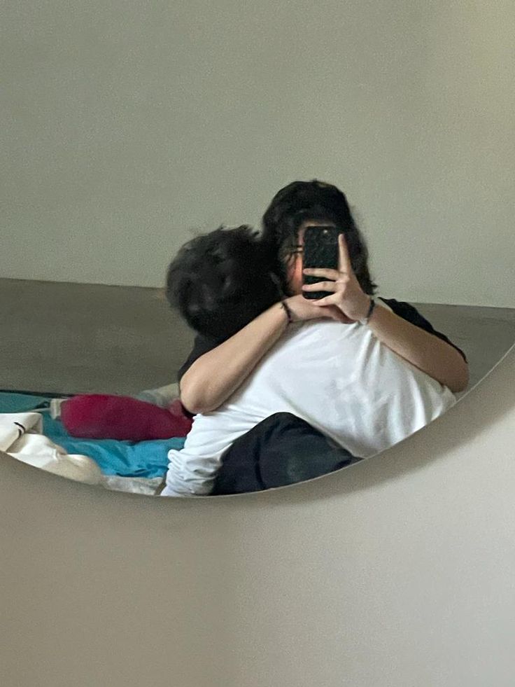 a man and woman taking a selfie in a mirror