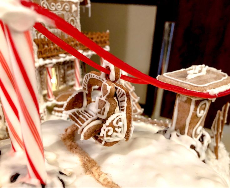 a gingerbread house decorated with icing and candy canes is shown in the foreground