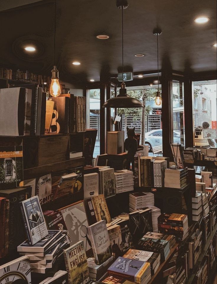 a room filled with lots of books next to a window