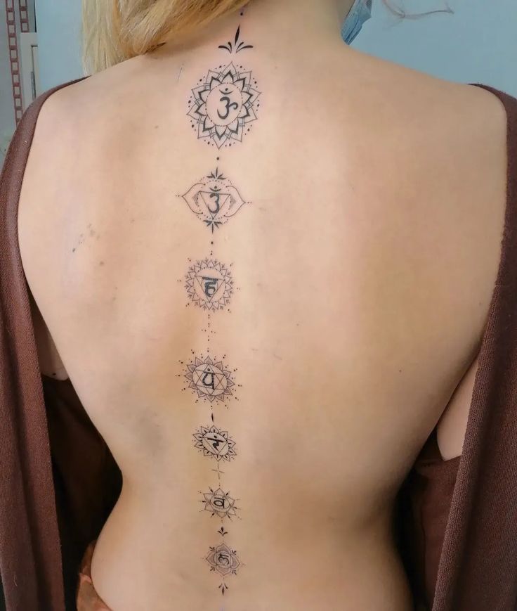 the back of a woman's body with seven chakragrams on it