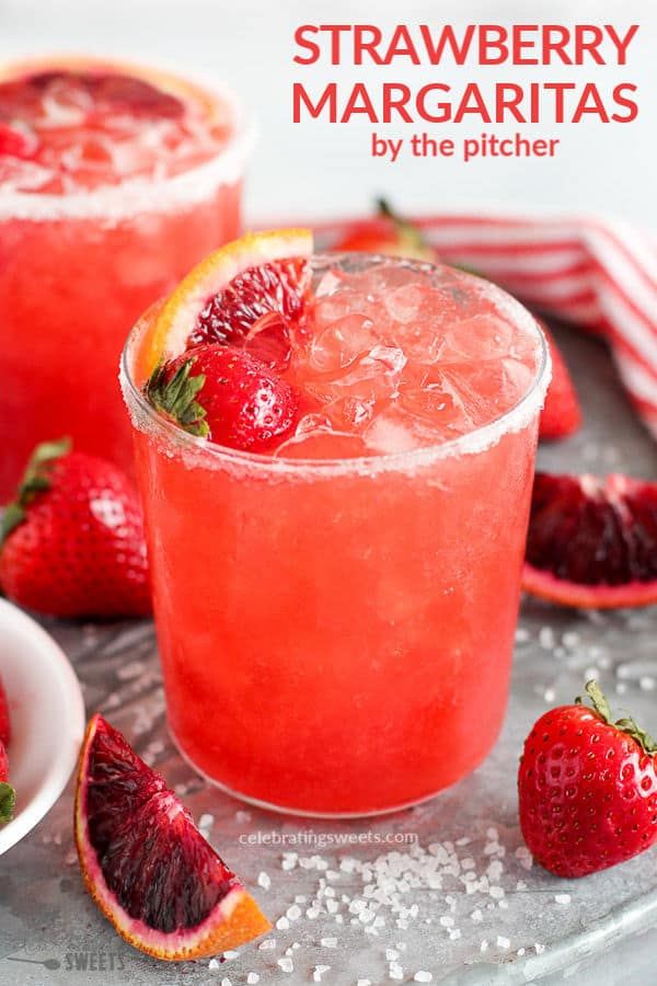 two glasses filled with watermelon lemonade and garnished with strawberries