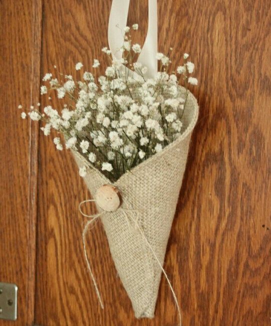 a bouquet of flowers is tied to a door handle on a wooden paneled door